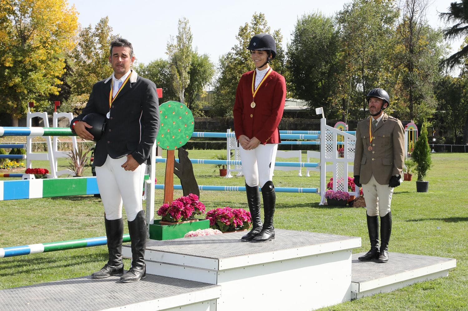 Primitivo Nieves, Paola Amilibia y Luis Fernández escuchan el himno de España en el podio. Foto: Miguel Ros